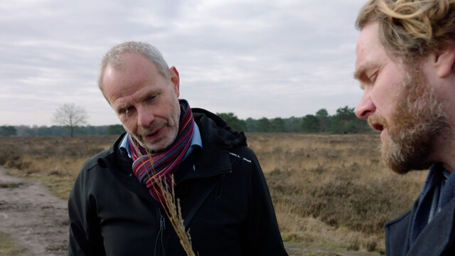 Hoogleraar en presentator praten met elkaar op de heide
